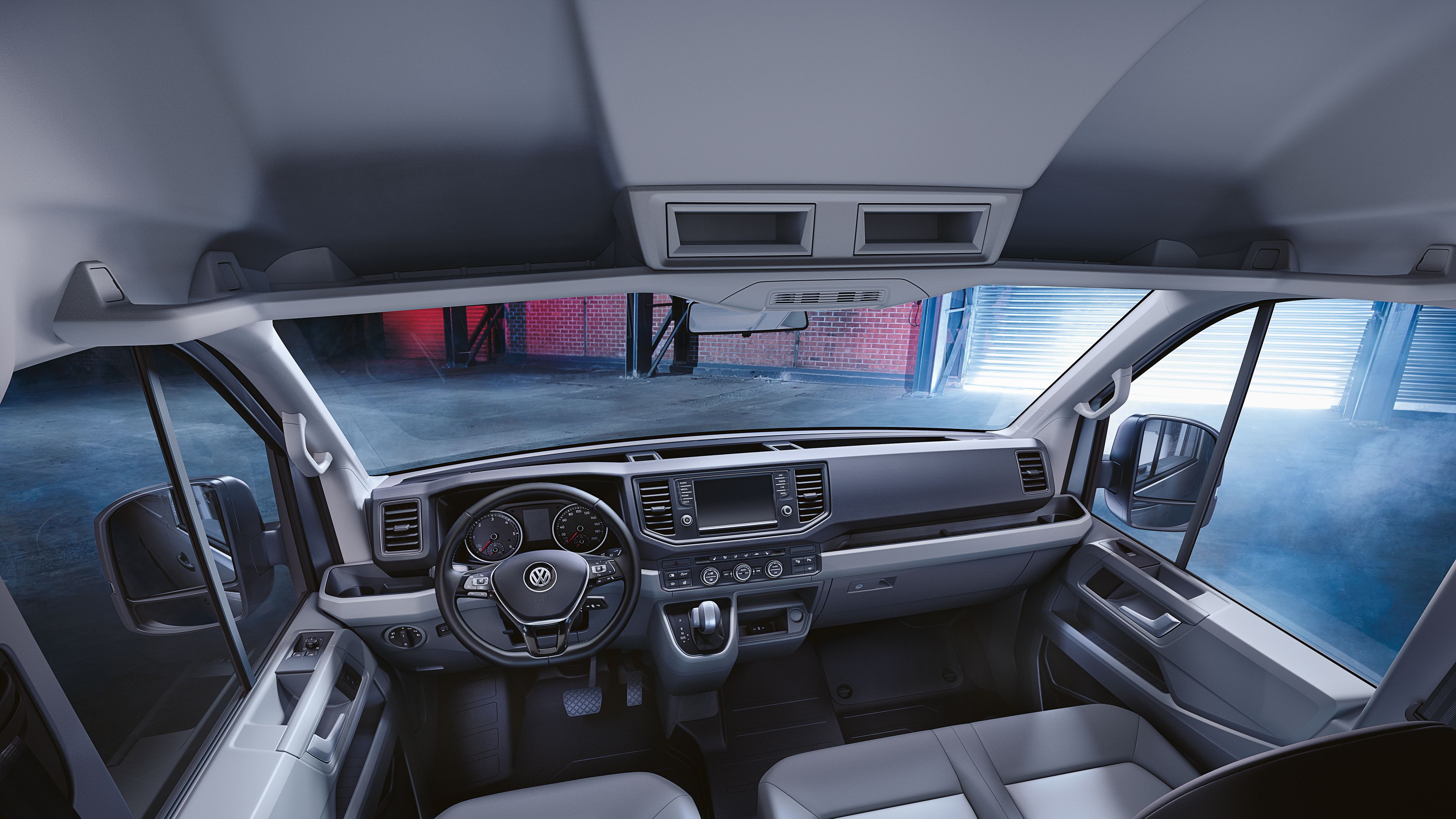 Ein Blick in die Fahrerkabine des Volkswagen Nutzfahrzeuge Crafter mit zahlreichen Ablagen und Fächern.