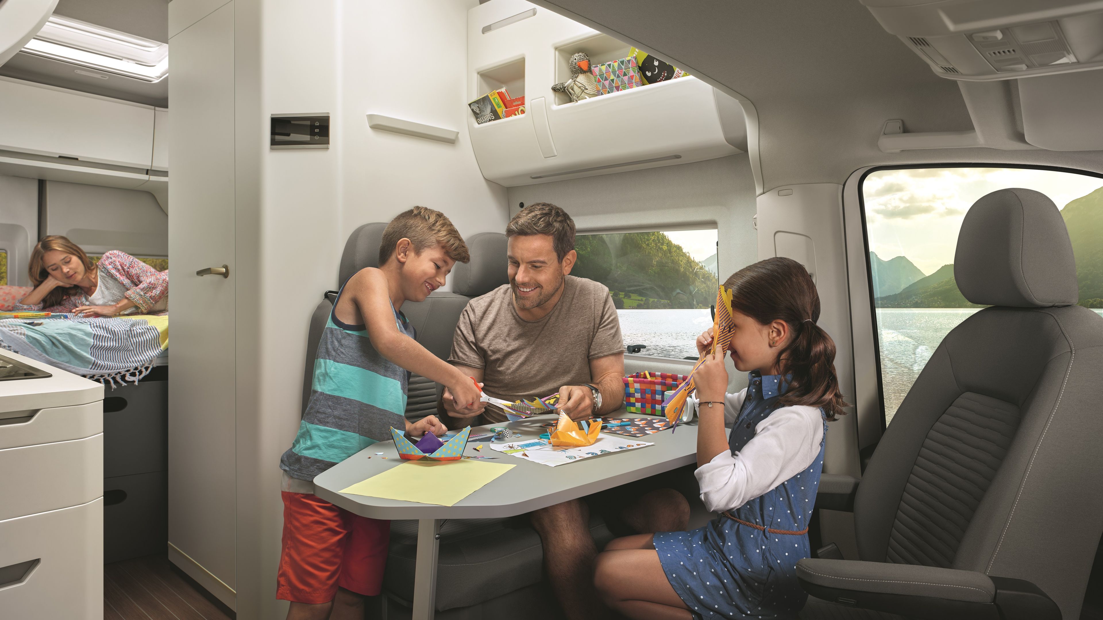 Familie sitzt in VW Grand California.